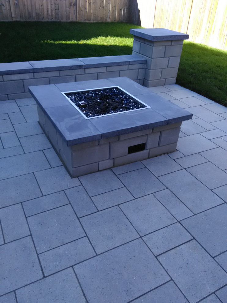 Inspiration for a mid-sized modern backyard patio in Ottawa with a fire feature and concrete pavers.