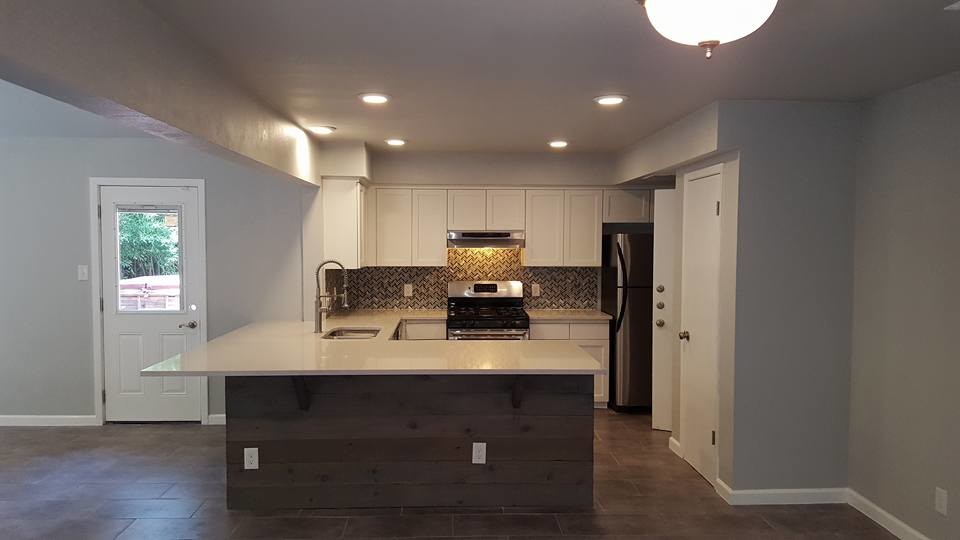 Inspiration for a mid-sized transitional l-shaped porcelain tile open concept kitchen remodel in Austin with an undermount sink, multicolored backsplash, glass tile backsplash, shaker cabinets, white cabinets, limestone countertops, stainless steel appliances and a peninsula