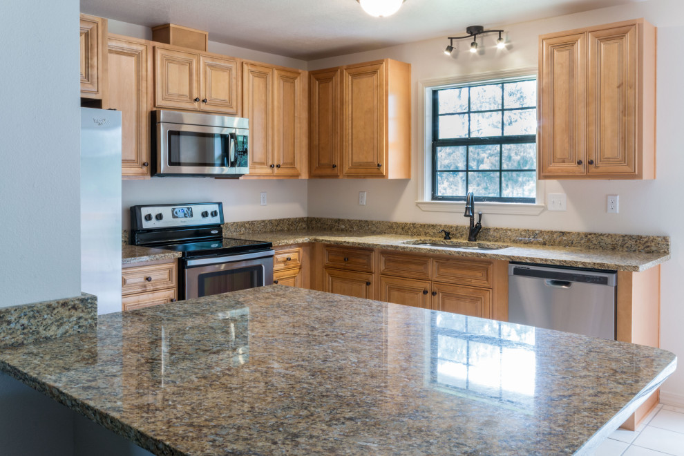 Eat-in kitchen - mid-sized l-shaped eat-in kitchen idea with an undermount sink, raised-panel cabinets, medium tone wood cabinets, granite countertops, ceramic backsplash, stainless steel appliances, a peninsula and brown countertops