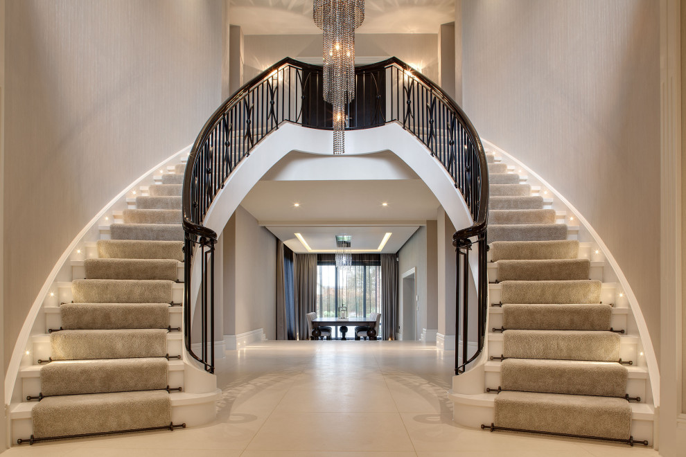 This is an example of a traditional wood curved staircase in London with wood risers and metal railing.