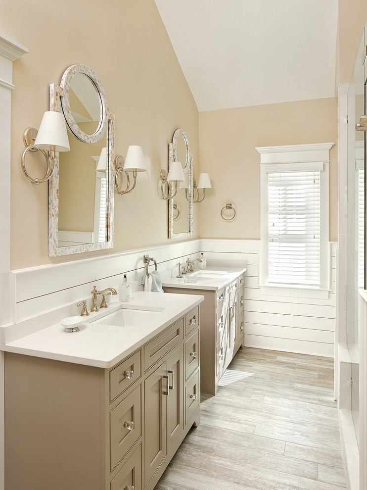 Photo of a beach style master bathroom in Charleston with an undermount sink, beige cabinets, engineered quartz benchtops, beige tile, beige walls and porcelain floors.