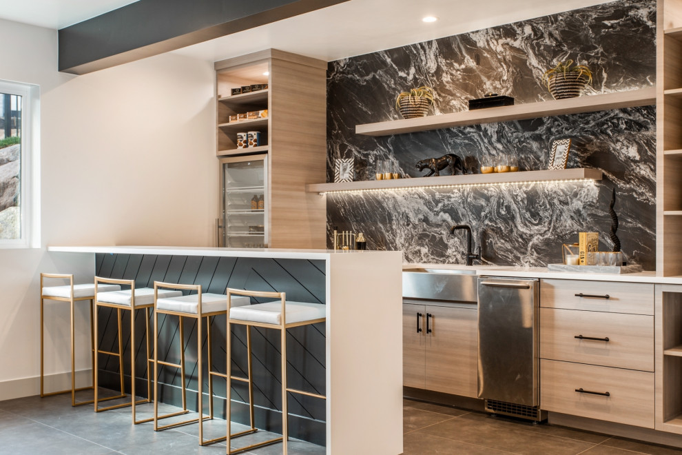 Design ideas for a contemporary single-wall home bar in Salt Lake City with an undermount sink, flat-panel cabinets, light wood cabinets, grey splashback, marble splashback, grey floor and white benchtop.