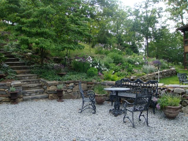 Photo of an expansive country backyard full sun garden for summer in New York with a retaining wall and natural stone pavers.