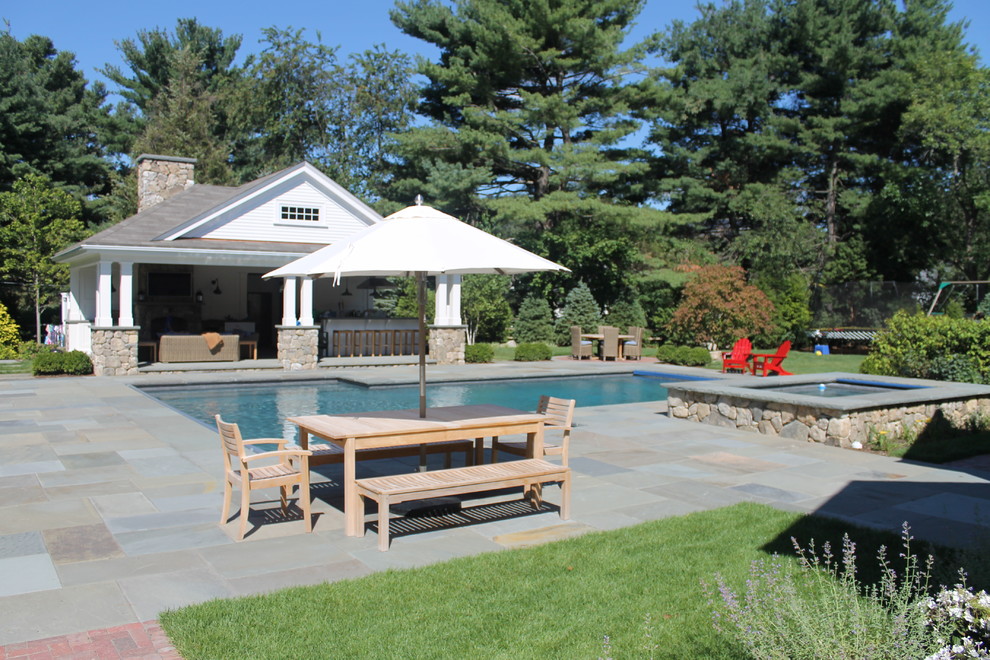 This is an example of a large country backyard custom-shaped natural pool in Boston with a hot tub and stamped concrete.