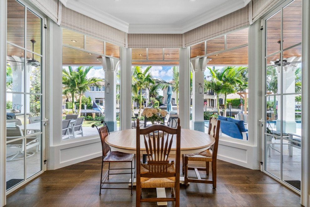 Photo of a large nautical dining room in Miami with banquette seating, white walls, medium hardwood flooring and brown floors.