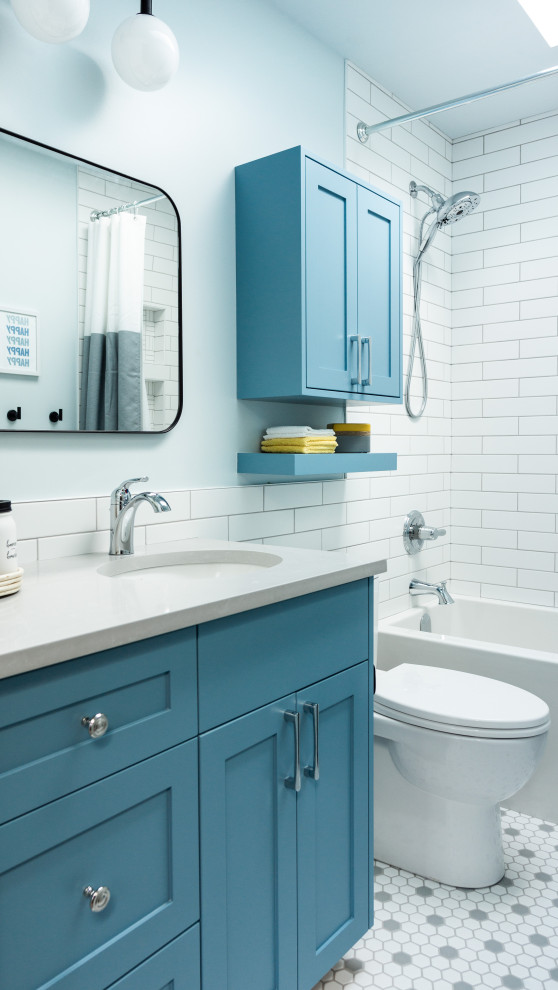 Idéer för att renovera ett mellanstort vintage grå grått badrum för barn, med skåp i shakerstil, blå skåp, ett badkar i en alkov, en dusch/badkar-kombination, vit kakel, blå väggar, ett undermonterad handfat, bänkskiva i kvarts, grått golv och dusch med duschdraperi