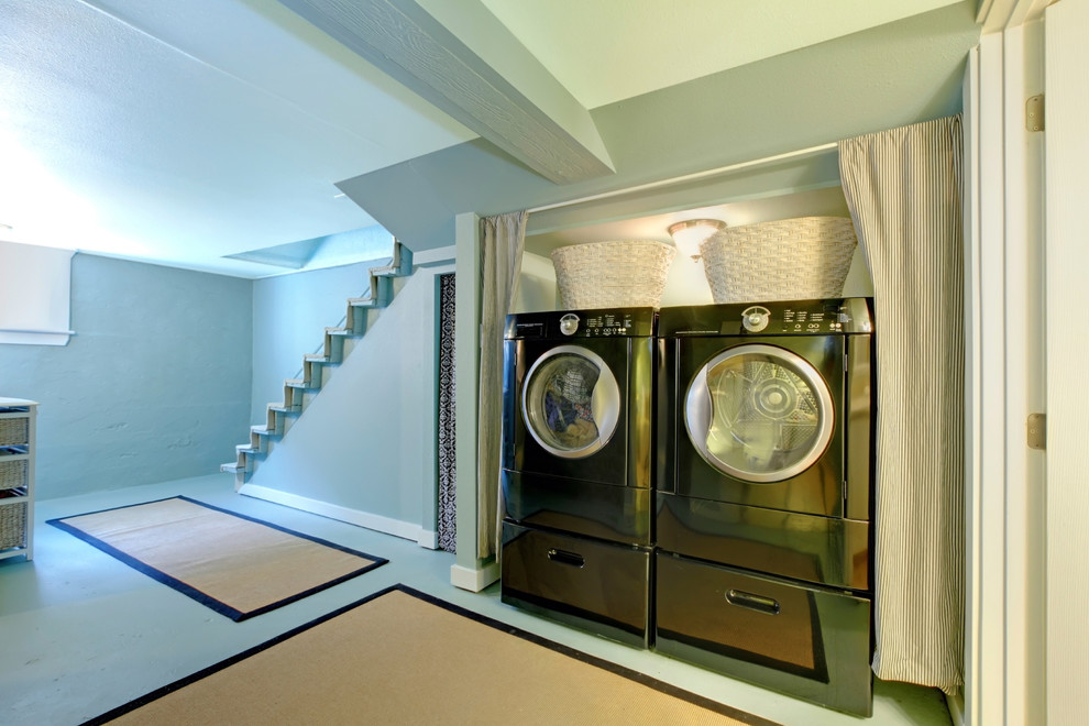 Photo of a mid-sized transitional laundry cupboard in Nashville with blue walls and a side-by-side washer and dryer.