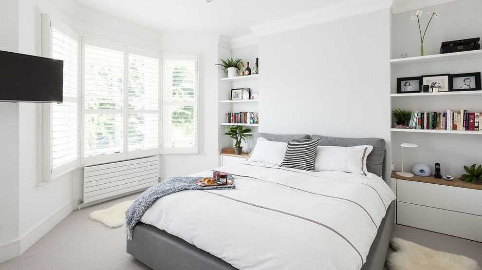 Scandinavian bedroom in London with white walls and carpet.