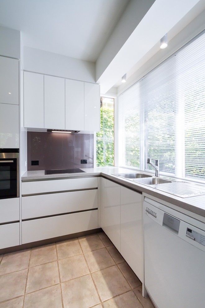 This is an example of a mid-sized modern u-shaped eat-in kitchen in Melbourne with a double-bowl sink, flat-panel cabinets, white cabinets, quartz benchtops, glass sheet splashback and with island.