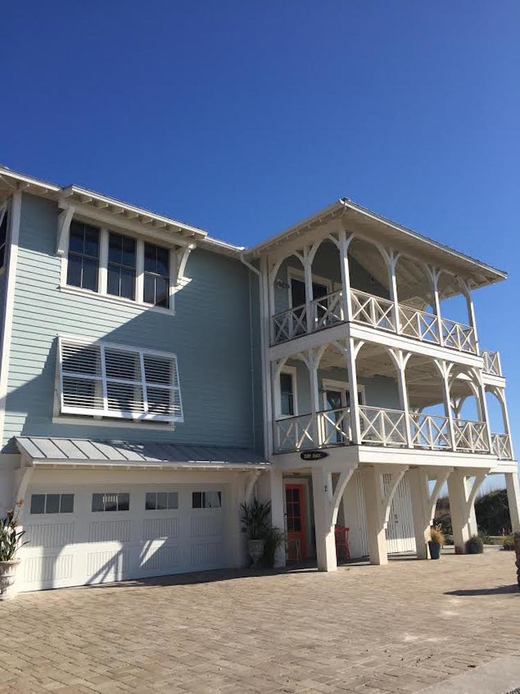 Photo of a mid-sized beach style two-storey blue exterior in Atlanta with vinyl siding.