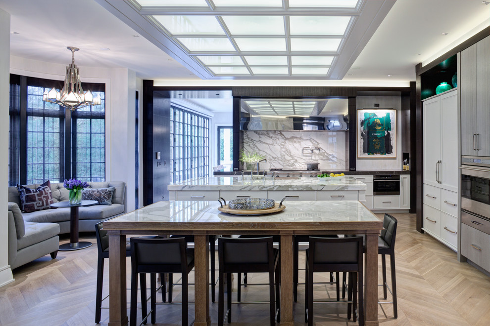 This is an example of a contemporary l-shaped eat-in kitchen in Chicago with white cabinets and white splashback.