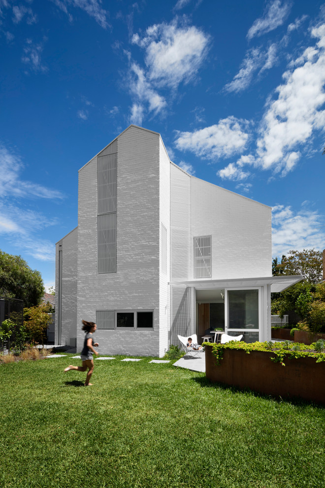 Design ideas for a large contemporary three-storey brick white exterior in Melbourne with a gable roof.