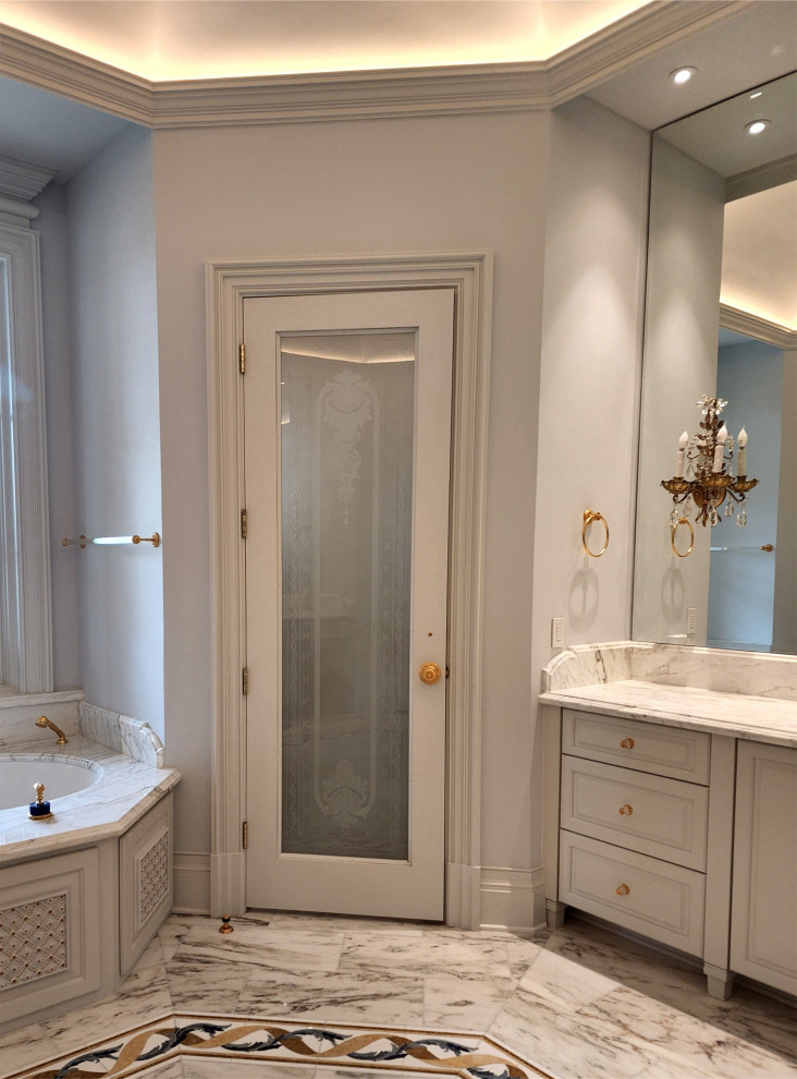 Photo of a large traditional master bathroom in Austin with recessed-panel cabinets, beige cabinets, an undermount tub, a corner shower, a bidet, beige walls, marble floors, an undermount sink, marble benchtops, beige floor, a hinged shower door, beige benchtops, an enclosed toilet, a double vanity, a built-in vanity and coffered.