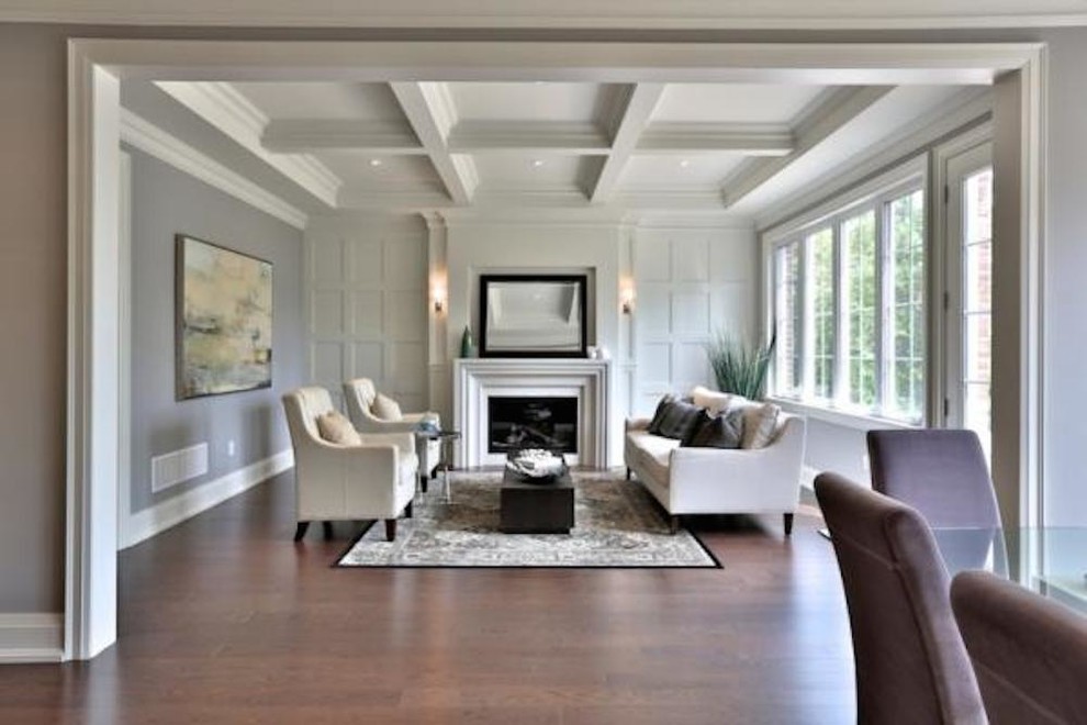 This is an example of a large contemporary formal open concept living room in Toronto with beige walls, medium hardwood floors, a standard fireplace and a stone fireplace surround.