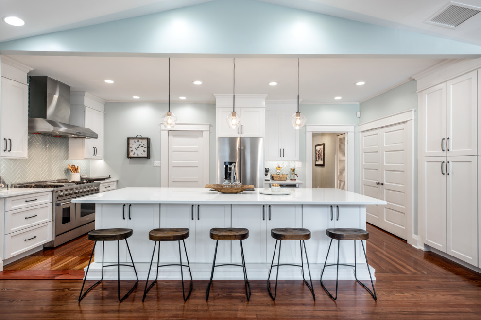 Large transitional u-shaped separate kitchen in Tampa with white cabinets, quartz benchtops, green splashback, glass tile splashback, stainless steel appliances, with island, brown floor, white benchtop, shaker cabinets and dark hardwood floors.