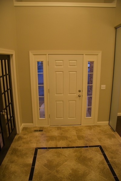 Foyer - traditional ceramic tile foyer idea with beige walls and a white front door