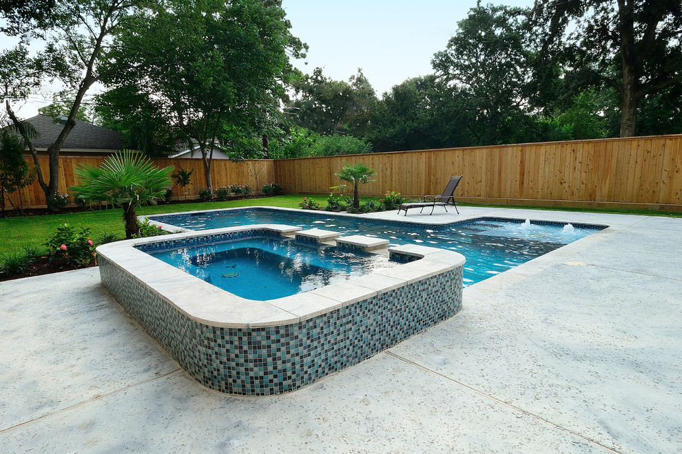 Photo of a large traditional backyard custom-shaped lap pool in Houston with a hot tub and concrete pavers.