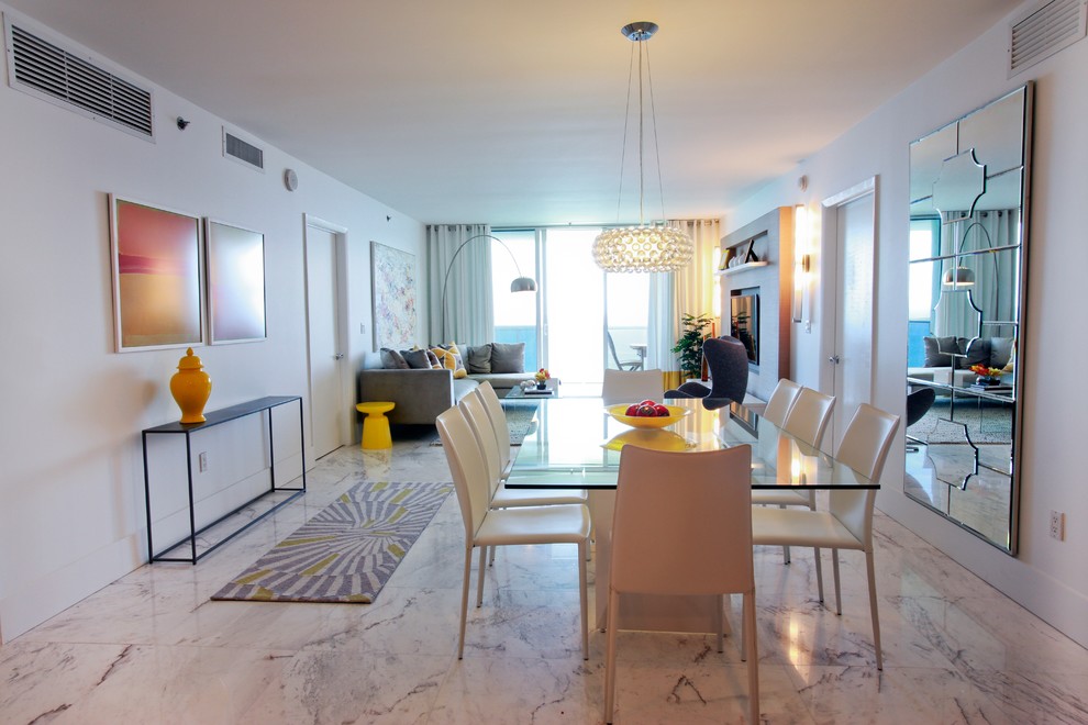 Photo of a contemporary dining room in Miami with white walls and marble floors.