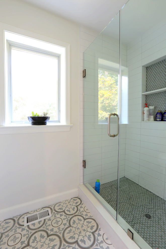 Inspiration for a mid-sized transitional 3/4 bathroom in DC Metro with a corner shower, white tile, yellow walls, porcelain floors, multi-coloured floor and a hinged shower door.