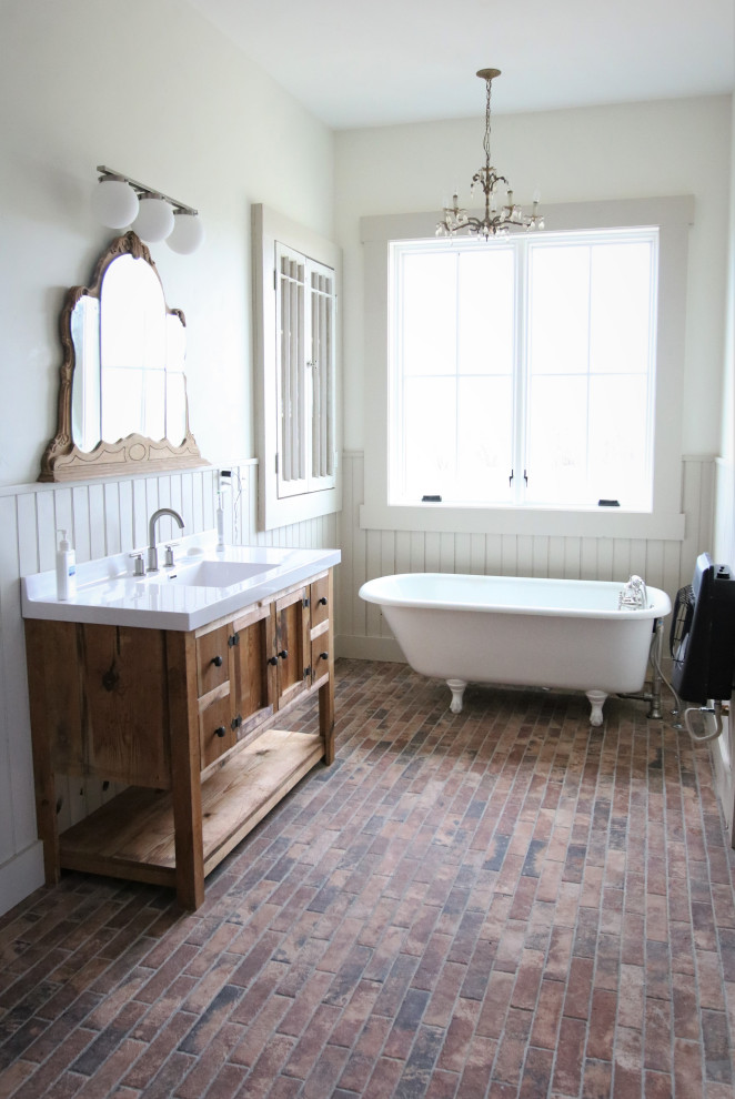 Inredning av ett lantligt stort en-suite badrum, med skåp i mellenmörkt trä, ett badkar med tassar, klinkergolv i porslin och flerfärgat golv