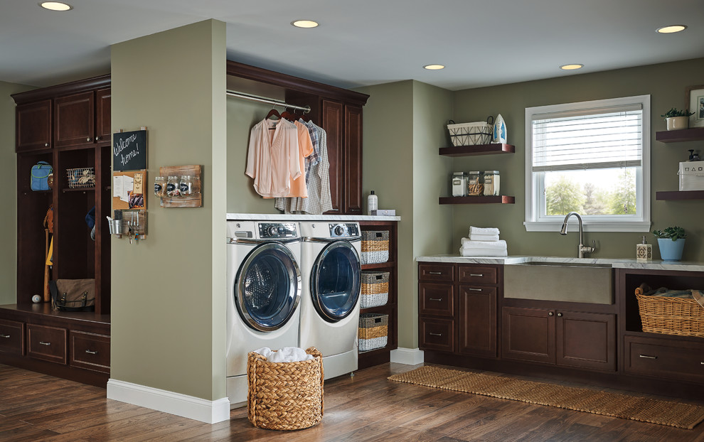 Design ideas for a mid-sized traditional dedicated laundry room in Other with shaker cabinets, dark wood cabinets, green walls, medium hardwood floors, a side-by-side washer and dryer, brown floor and grey benchtop.