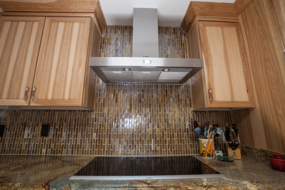 Example of a large transitional galley ceramic tile enclosed kitchen design in Phoenix with an undermount sink, recessed-panel cabinets, light wood cabinets, granite countertops, brown backsplash, glass tile backsplash and stainless steel appliances