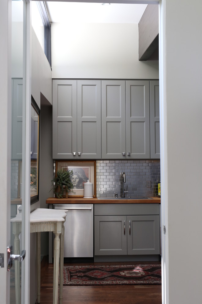 Midcentury kitchen in Other with shaker cabinets, grey cabinets, dark hardwood floors, grey splashback and metal splashback.