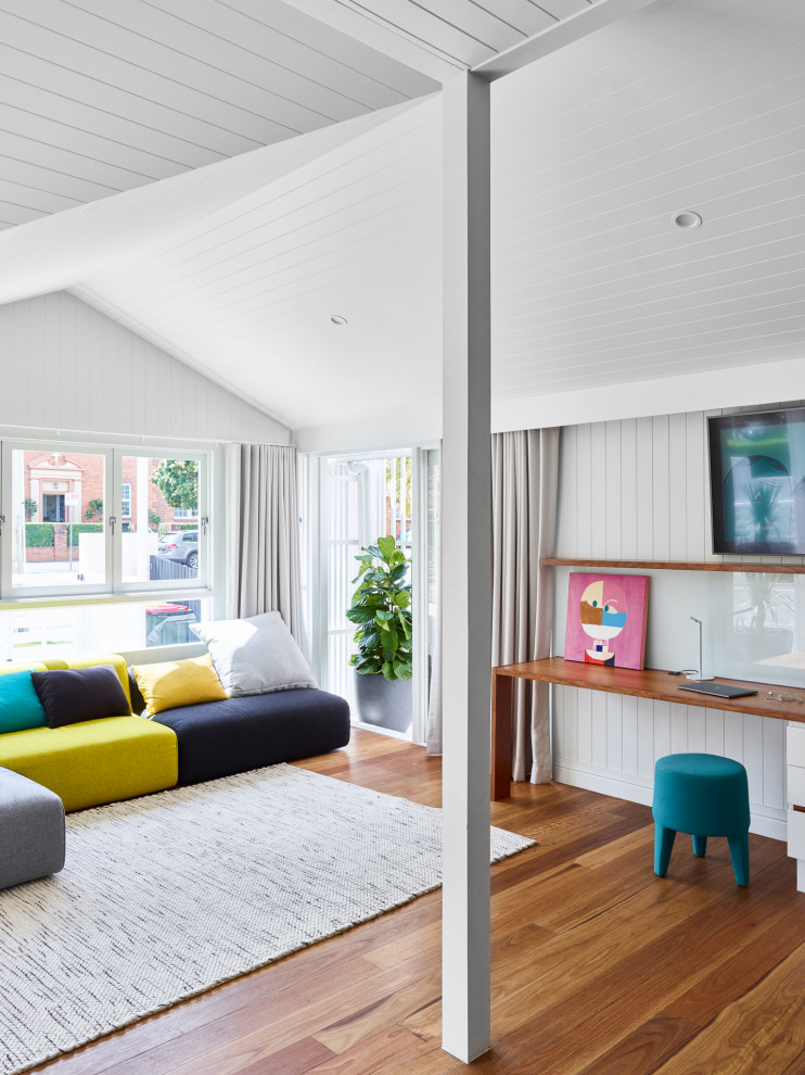 Photo of a large contemporary study room in Brisbane with white walls, light hardwood floors, a built-in desk, brown floor, vaulted and decorative wall panelling.