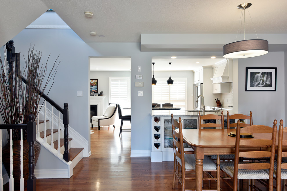 Open concept kitchen - large transitional u-shaped light wood floor and beige floor open concept kitchen idea in Ottawa with an undermount sink, shaker cabinets, white cabinets, granite countertops, white backsplash, subway tile backsplash, stainless steel appliances, an island and gray countertops