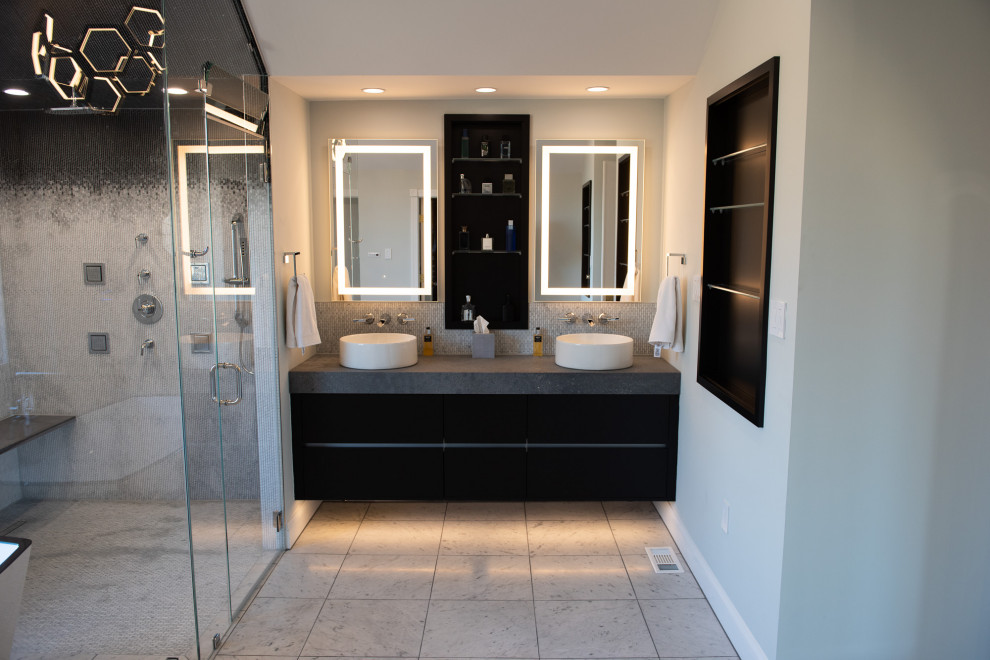 Large contemporary master bathroom in Philadelphia with flat-panel cabinets, black cabinets, a freestanding tub, an alcove shower, a wall-mount toilet, black and white tile, marble, a vessel sink, granite benchtops, a hinged shower door, grey benchtops, a double vanity, a floating vanity, blue walls, porcelain floors, white floor, a shower seat and vaulted.