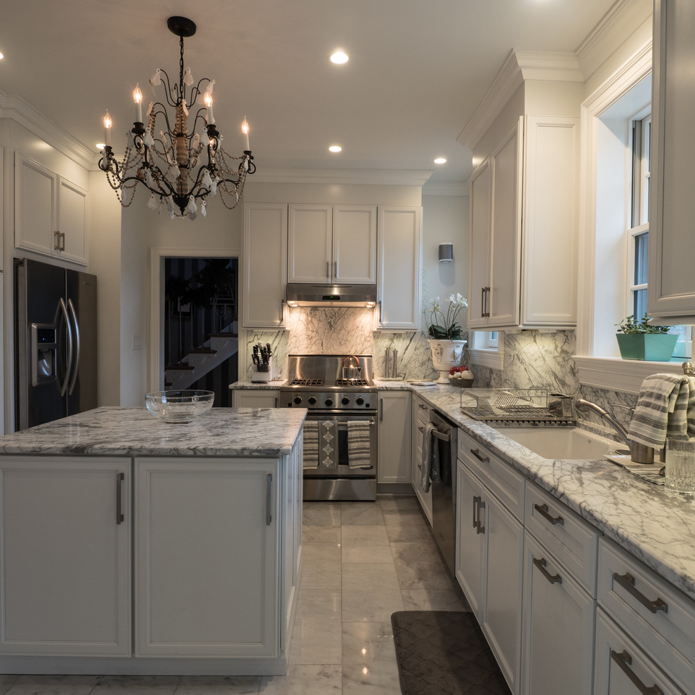 Photo of a mid-sized transitional l-shaped kitchen in DC Metro with an undermount sink, recessed-panel cabinets, white cabinets, quartzite benchtops, grey splashback, stone slab splashback, stainless steel appliances, marble floors, with island and grey floor.