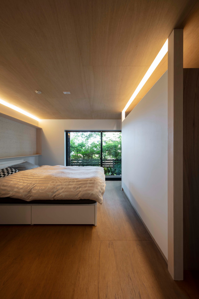 Пример оригинального дизайна: маленькая хозяйская спальня: освещение с белыми стенами, полом из фанеры, коричневым полом, деревянным потолком и обоями на стенах без камина для на участке и в саду