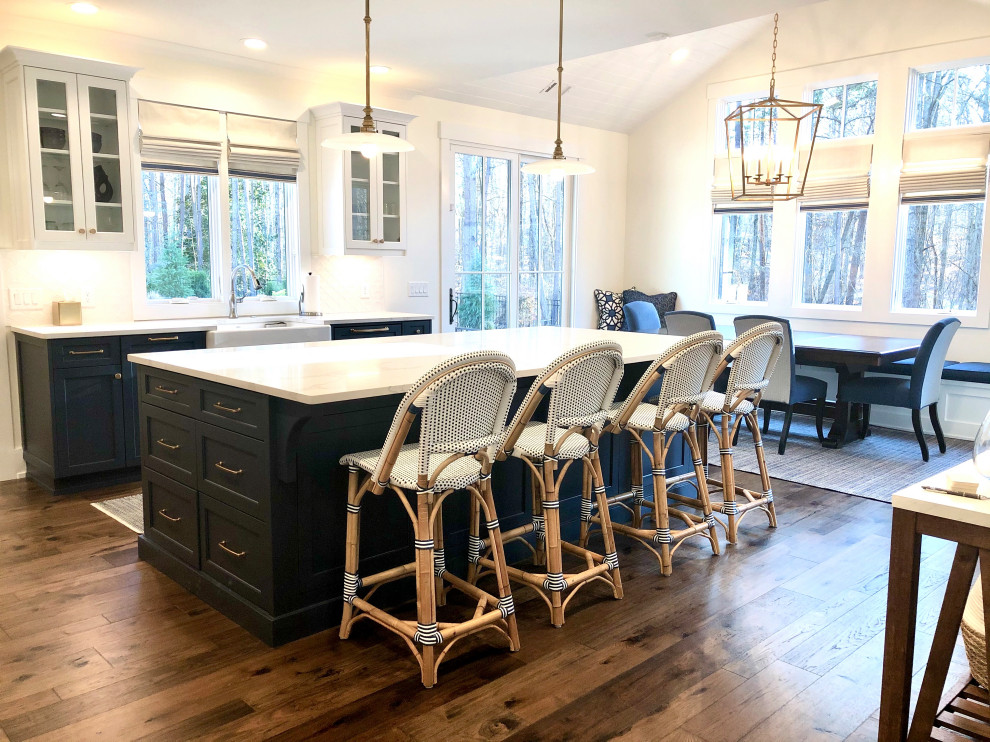 Inspiration for a mid-sized transitional l-shaped eat-in kitchen in Atlanta with a farmhouse sink, flat-panel cabinets, blue cabinets, marble benchtops, white splashback, window splashback, panelled appliances, dark hardwood floors, with island, brown floor, white benchtop and vaulted.