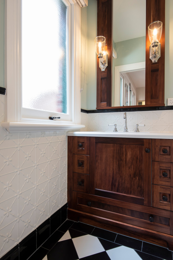 This is an example of a large traditional powder room in Melbourne with shaker cabinets, dark wood cabinets, a one-piece toilet, white tile, metal tile, green walls, porcelain floors, an undermount sink, engineered quartz benchtops and white benchtops.