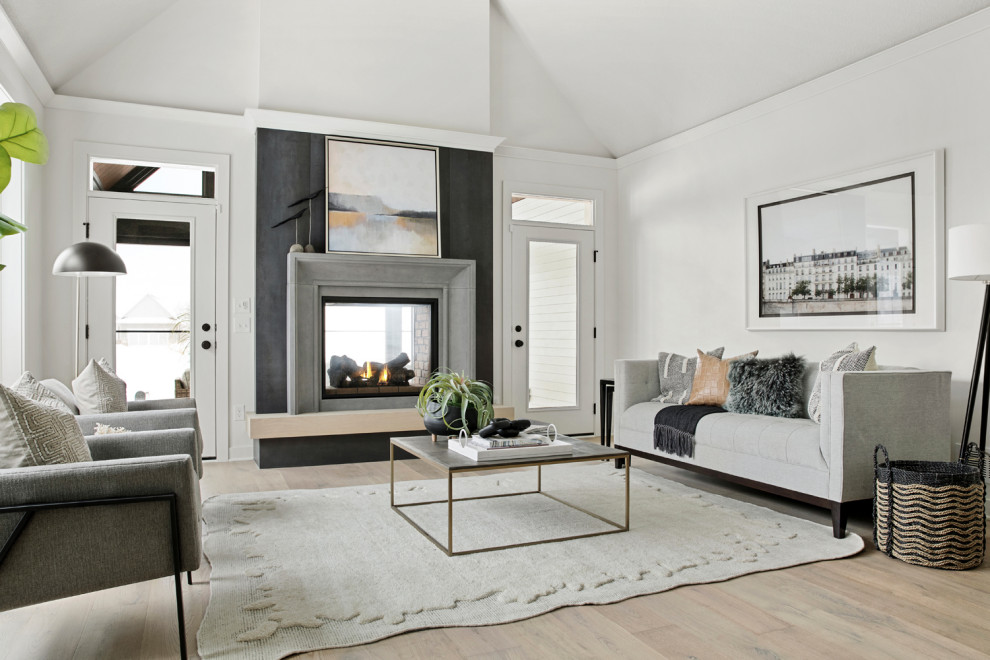 Offenes Skandinavisches Wohnzimmer mit weißer Wandfarbe, hellem Holzboden, Tunnelkamin, Kaminumrandung aus Stein und gewölbter Decke in Minneapolis