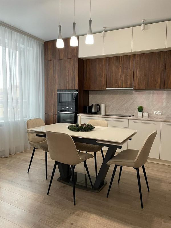 Inspiration for a medium sized classic single-wall kitchen/diner in Moscow with a built-in sink, flat-panel cabinets, beige cabinets, composite countertops, beige splashback, porcelain splashback, white appliances, laminate floors, no island, beige floors and beige worktops.