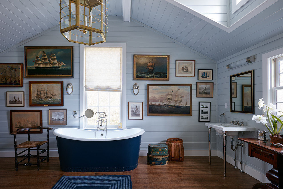Photo of a traditional master bathroom in New York with a freestanding tub, blue walls, dark hardwood floors, an undermount sink, brown floor and white benchtops.