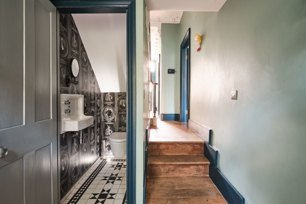 Kleine Eklektische Gästetoilette mit Wandtoilette, schwarzer Wandfarbe, Keramikboden, Wandwaschbecken, schwarzem Boden, eingebautem Waschtisch, gewölbter Decke und Tapetenwänden in London