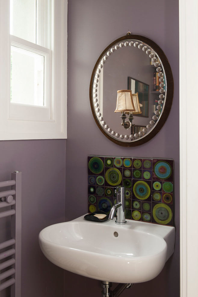 This is an example of a mid-sized traditional kids bathroom in Sussex with a one-piece toilet, multi-coloured tile, ceramic tile, purple walls, dark hardwood floors and a wall-mount sink.