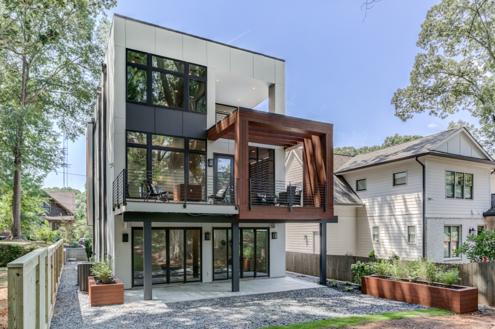 Mid-sized modern three-storey white house exterior in Atlanta with concrete fiberboard siding and a flat roof.
