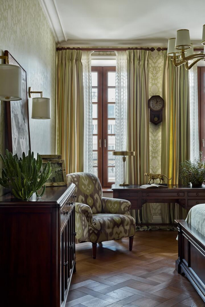 Imagen de dormitorio principal clásico de tamaño medio sin chimenea con paredes verdes, suelo de madera en tonos medios, suelo marrón y papel pintado
