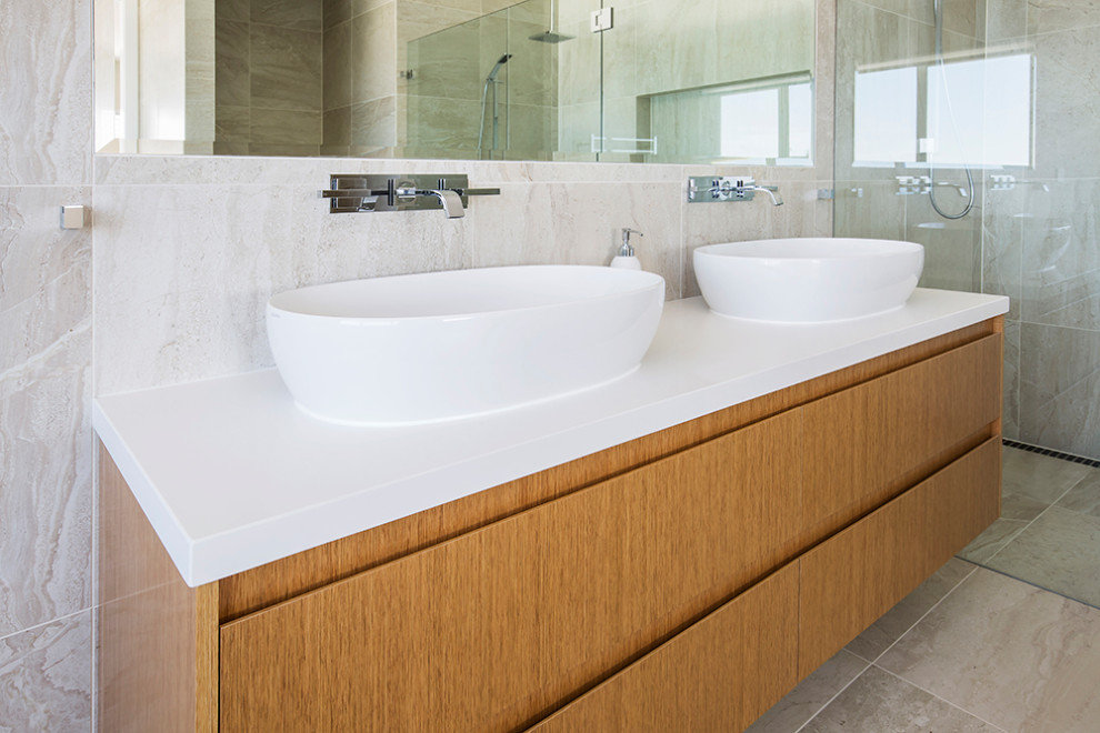 Photo of a large modern master bathroom in Sydney with furniture-like cabinets, light wood cabinets, a freestanding tub, a double shower, a one-piece toilet, white tile, travertine, beige walls, limestone floors, a vessel sink, engineered quartz benchtops, beige floor, a hinged shower door, white benchtops, a double vanity, a floating vanity and coffered.