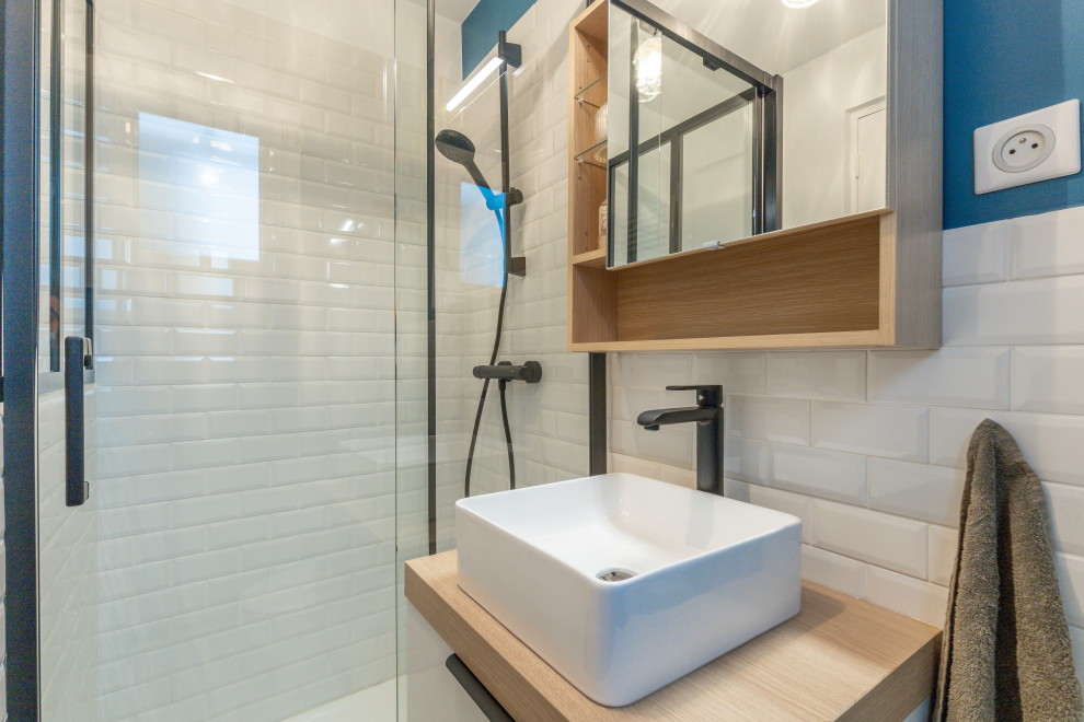 На фото: маленькая главная ванная комната в скандинавском стиле с фасадами с декоративным кантом, светлыми деревянными фасадами, открытым душем, унитазом-моноблоком, белой плиткой, плиткой кабанчик, синими стенами, полом из цементной плитки, консольной раковиной, столешницей из дерева, синим полом, душем с раздвижными дверями, бежевой столешницей, нишей, тумбой под одну раковину и подвесной тумбой для на участке и в саду с