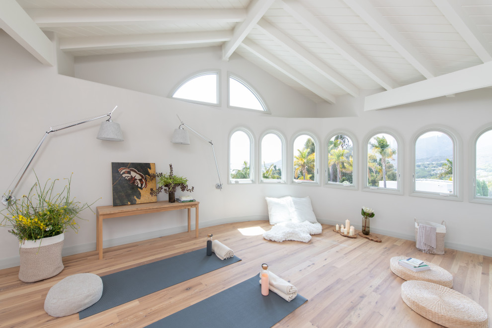 Идея дизайна: огромная йога-студия в морском стиле с белыми стенами, светлым паркетным полом, коричневым полом и балками на потолке