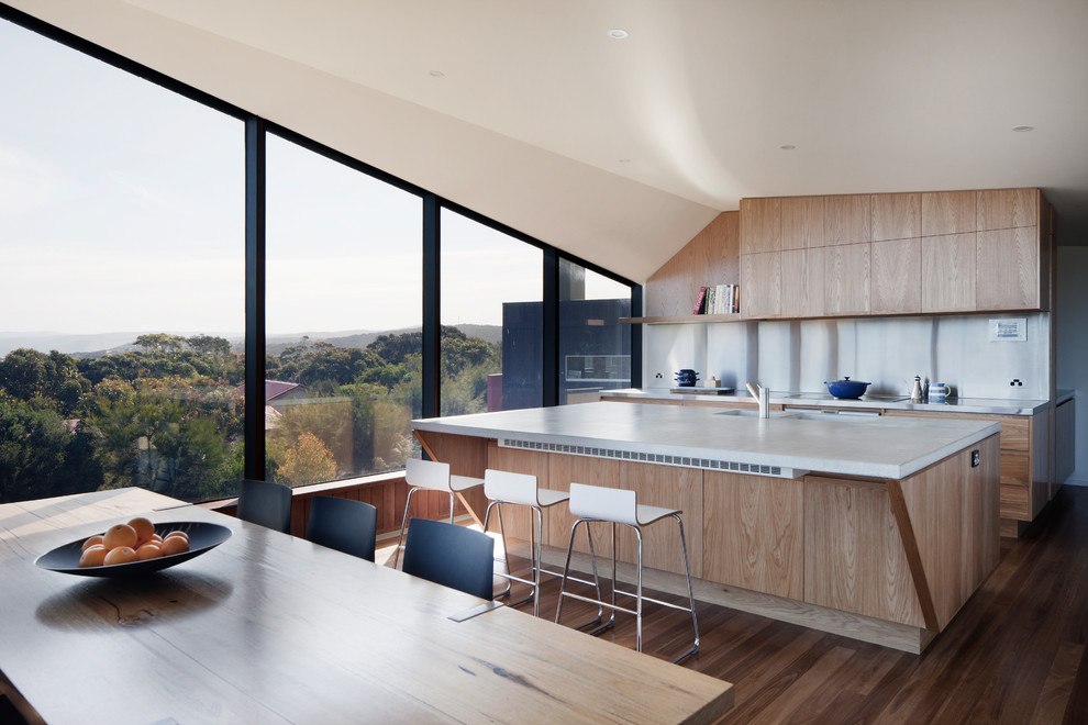 Design ideas for a contemporary galley eat-in kitchen in Geelong with a double-bowl sink, flat-panel cabinets, light wood cabinets, white splashback, stainless steel appliances, dark hardwood floors, with island, brown floor and white benchtop.