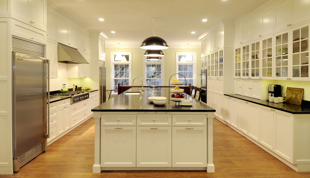 Design ideas for a large transitional galley kitchen in New York with an undermount sink, flat-panel cabinets, white cabinets, quartz benchtops, black splashback, stainless steel appliances and with island.