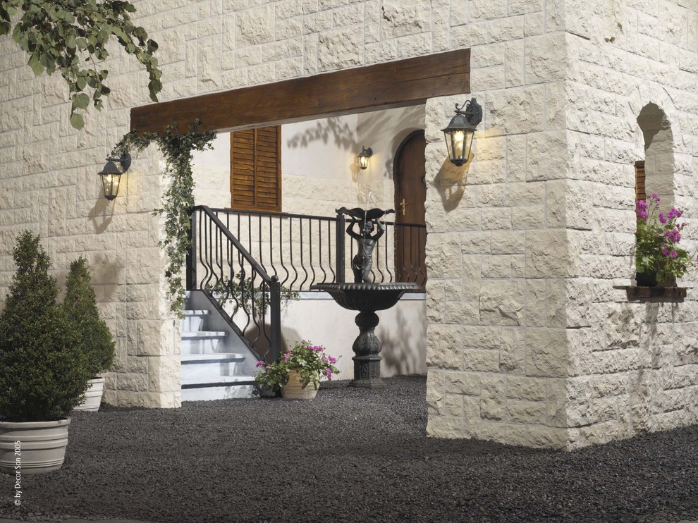 This is an example of a mid-sized mediterranean two-storey white exterior in New York with stone veneer.
