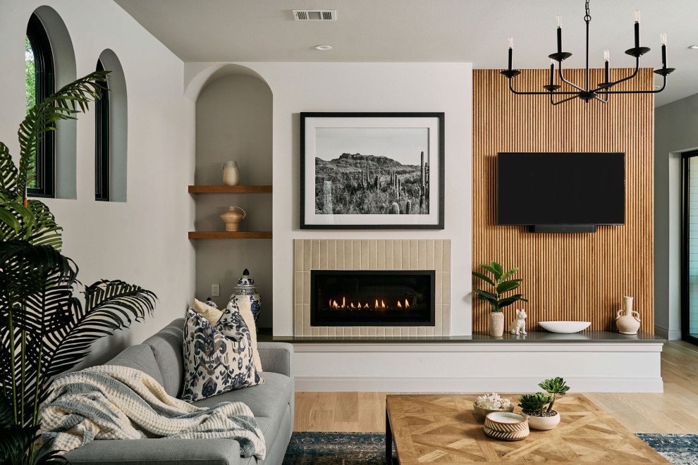 Inspiration for a transitional light wood floor and beige floor living room remodel in Austin with white walls, a standard fireplace, a tile fireplace and a wall-mounted tv
