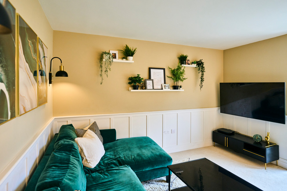 На фото: парадная, открытая гостиная комната среднего размера с бежевыми стенами, ковровым покрытием, телевизором на стене, бежевым полом и панелями на части стены