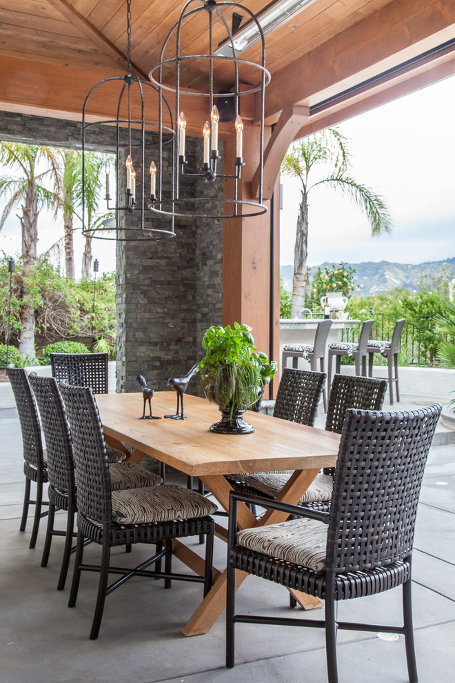 Example of a large classic backyard concrete patio design in Los Angeles with a roof extension